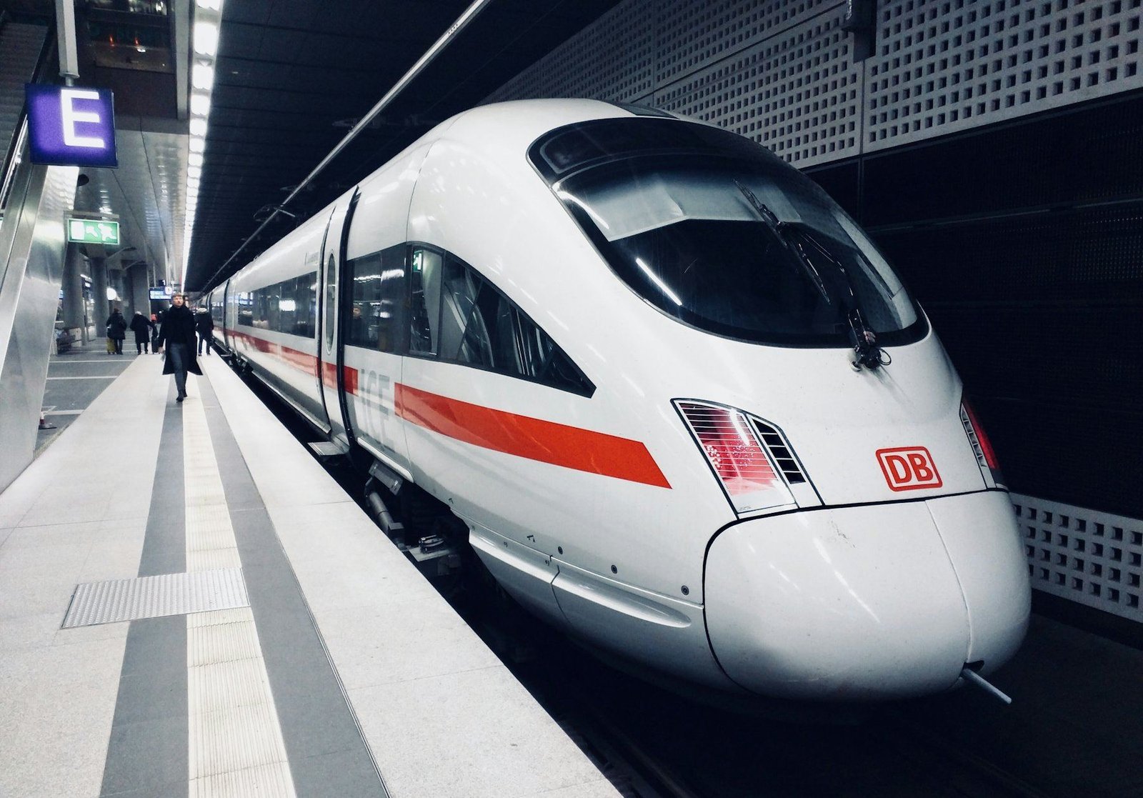 A white high-speed train standing at a station platform