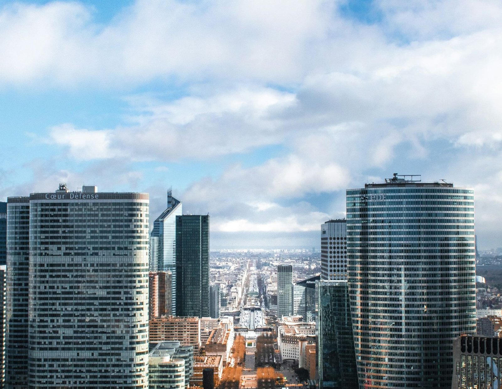 Glass office towers of La Défense, the business district west of Paris, under a bright sky