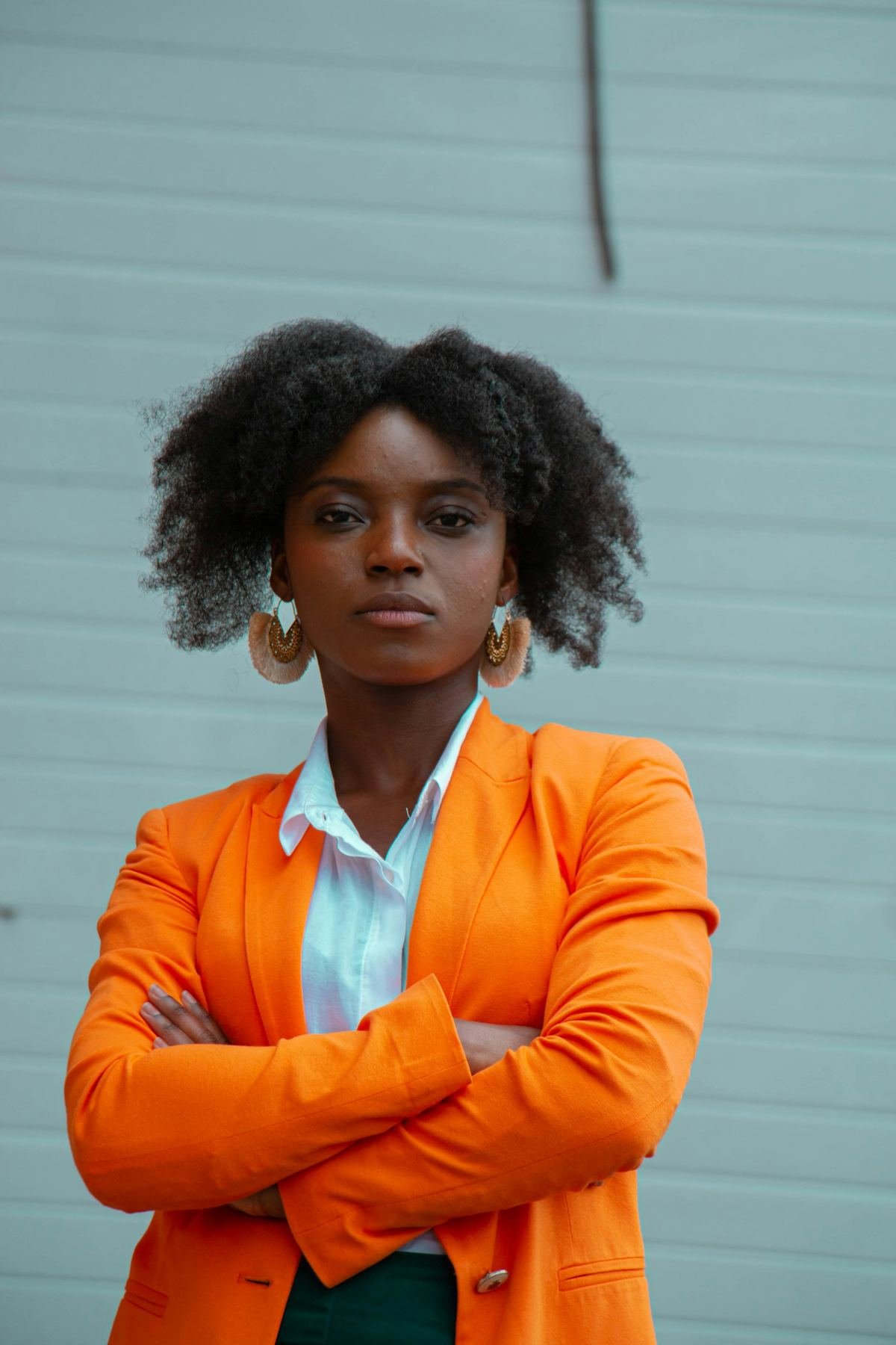 A woman in an orange blazer standing on a city street